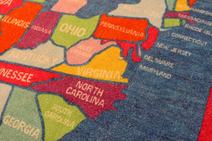 A carpet designed with Virginia and the rest of the United States lies inside a classroom. (Photo by Nathaniel Cline/Virginia Mercury)