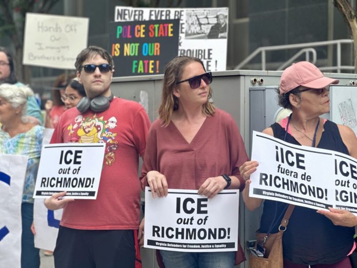 Activists rally outside Richmond City Hall last August, holding signs and calling for an end to what they describe as aggressive immigration enforcement tactics in Virginia. (Photo by Markus Schmidt/Virginia Mercury)