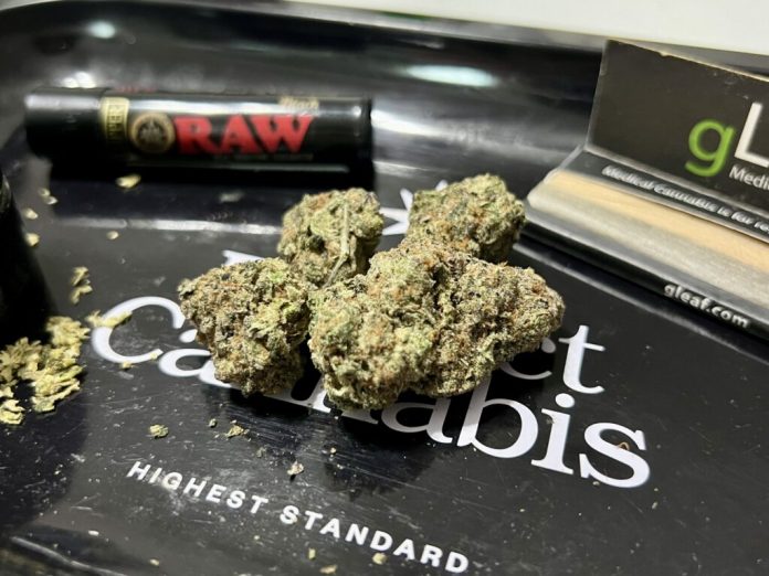 Cannabis flower rests on a rolling tray, surrounded by a pack of rolling papers, a grinder and a lighter. Lawmakers in a handful of states this year have introduced legislation to impose stricter THC limits on certain cannabis products. Photo by Amanda Watford/Stateline)